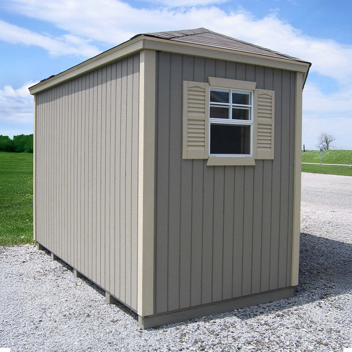 Little Cottage Co. Classic Five Corner Shed side view with decorative shuttered window, vertical wood panels, and pitched roof set on gravel foundation