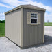Little Cottage Co. Classic Five Corner Shed side view with decorative shuttered window, vertical wood panels, and pitched roof set on gravel foundation