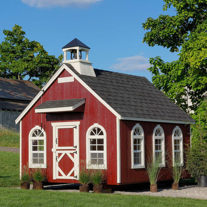 Red Stratford Schoolhouse playhouse by Little Cottage Co. featuring white trim, bell tower, and arched windows, perfect for backyard or garden use