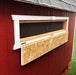Close-up of Little Cottage Co. Gambrel Barn Chicken Coop showing mesh ventilation window with wooden frame and hinged cover for airflow control.