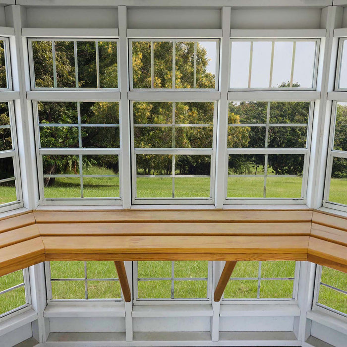Lifestyle setting of the Garden Shed Greenhouse from Little Cottage Co. with flowers and outdoor decor.