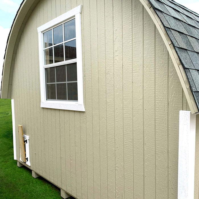 Back view of the Little Cottage Co. Round Roof Chicken Coop in beige with white trim, featuring a large window and arched roof design.