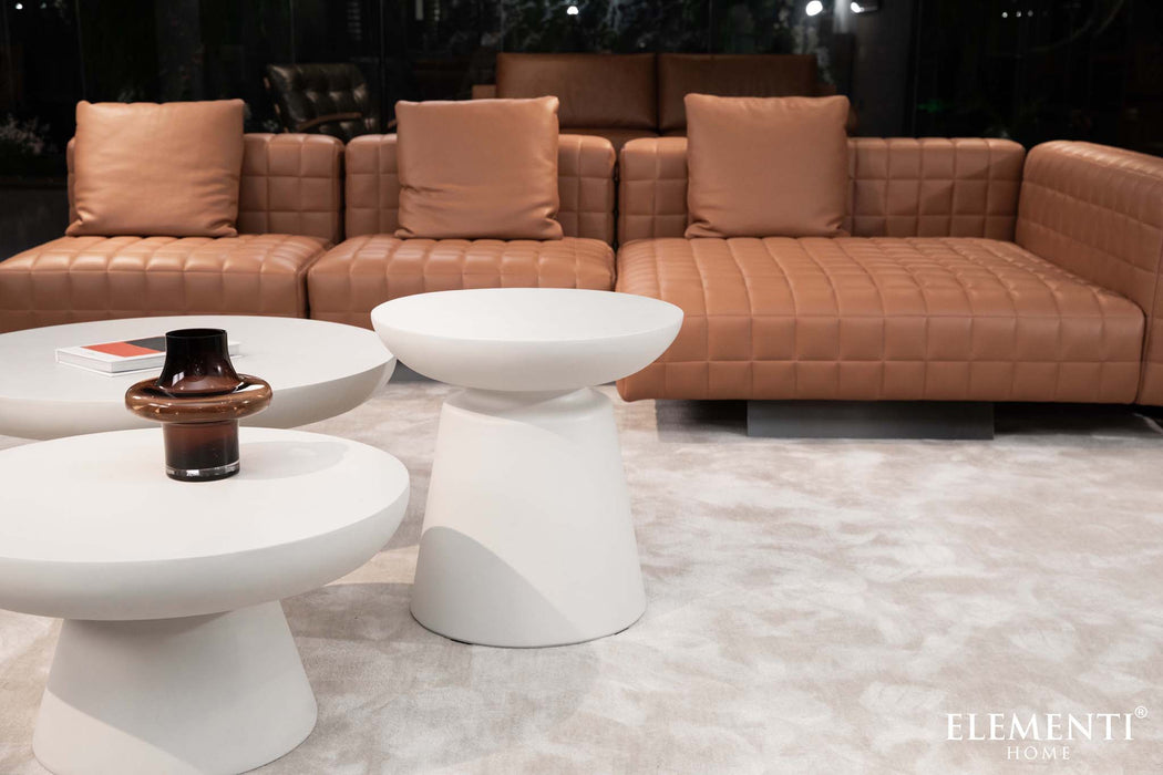 Living room setup with Kylix series  cream white side table alongside leather sofas, styled with decor items.