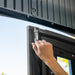 Close-up of a hand adjusting the hinge of a Lifetime 8x10 Shed during installation, demonstrating ease of assembly.