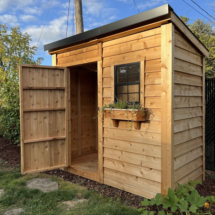 Cedar-sided SpaceSaver 8x4 storage shed with a black metal roof and open single door, shown from an angled view.