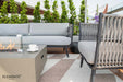 Elegant Elementi Outdoor Furnitures Milano Collection sofa on a deck, with a modern fire pit table creating a cozy and stylish ambiance.