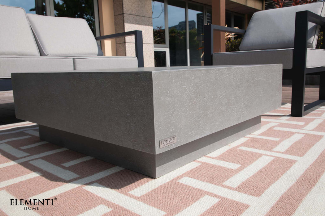 Close-up view of a modern outdoor seating arrangement featuring the Elementi Tevere Series Square Coffee Table in Space Grey paired with stylish lounge chairs.