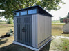 Lifetime Modern Shed installed in a backyard with a rural field view, front angle, closed doors.