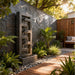 Modern Zen cascade outdoor water fountain with tiered stone design, placed against slate wall with lush greenery and wood deck