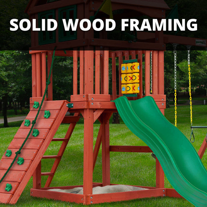 Close-up of solid wood framing on the Gorilla Playsets Nantucket II showing rock wall, green slide, sandbox, and tic-tac-toe panel
