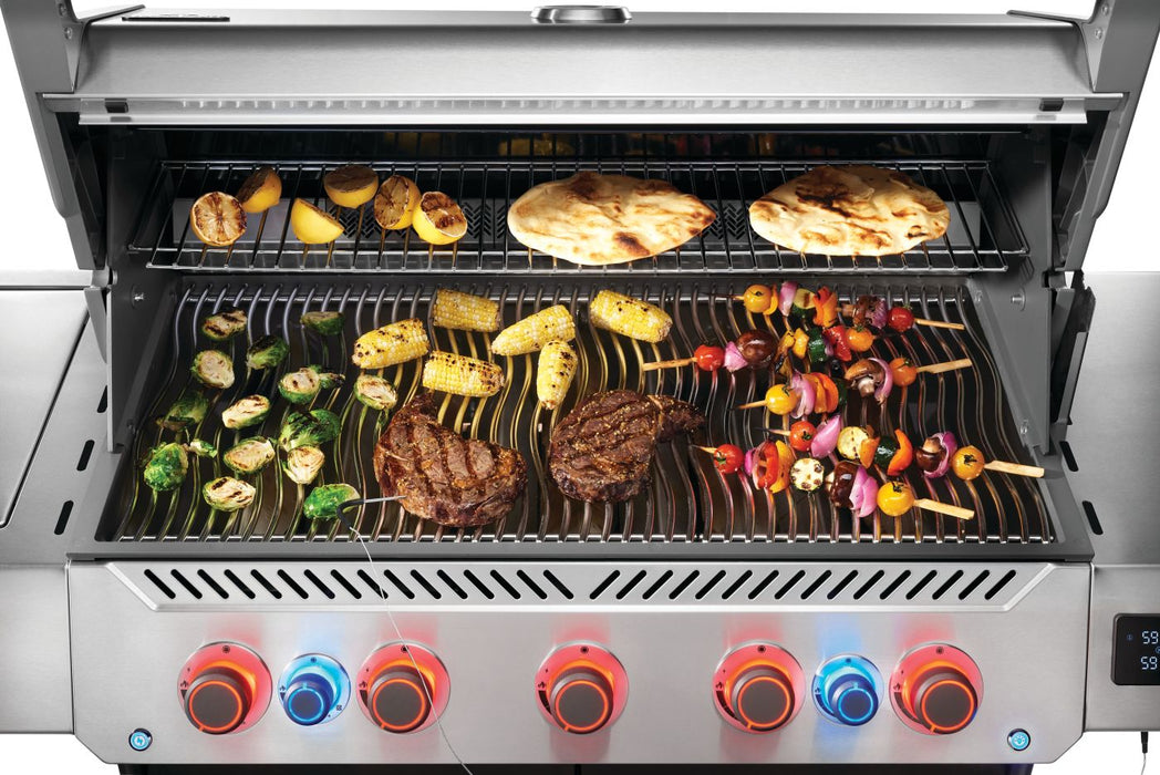 Top-down view of Napoleon Grills Prestige® 665 RSIB grilling steaks, corn, veggies, and naan with a probe inserted