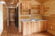 Interior hallway of the Firestack Cabin with seamless wood paneling and efficient space use, leading to various rooms.