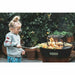 A child cooking on the Arteflame One 20 Grill, a family-friendly and safe grill option, highlighting its easy accessibility and outdoor fun for all ages.