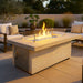 Phoenix 48-inch rectangular fire pit from Cal Flame lit on a modern patio with seating and glass wind guard.