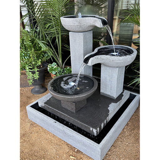 An outdoor garden scene showcasing the Exaco Trio Bowl Fountain. 