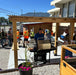 Outdoor grill gazebo sheltering a BBQ station during a group cookout and food service setup