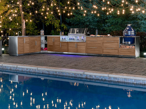 Luxury backyard setup featuring NewAge Outdoor Kitchen Platinum Grill with cabinets, wood accents, string lights, and poolside entertainment space.
