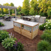 Outdoor Living Today Greenhouse with Garden in a Box 6x3 cedar raised bed with closed polycarbonate lids beside a paver patio and outdoor kitchen