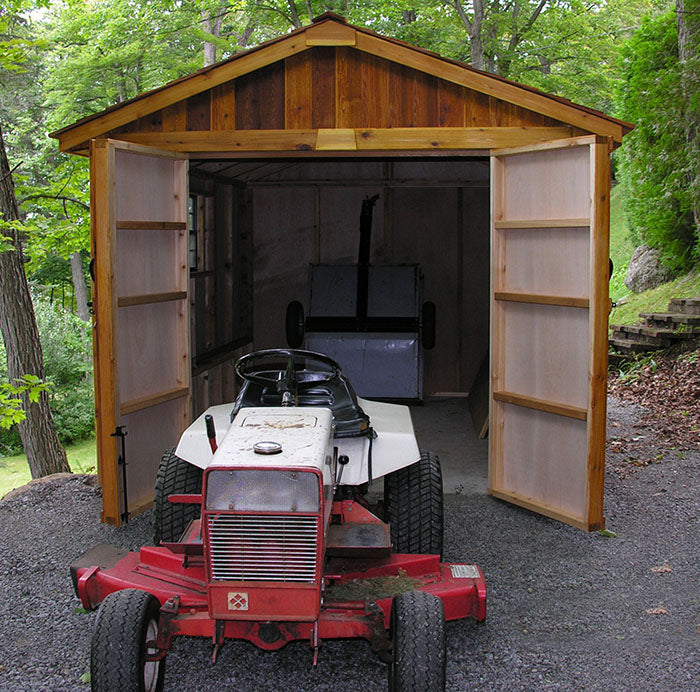 Riding mower parked in front of the open doors of Outdoor Living Today Space Master 8x12 wooden shed