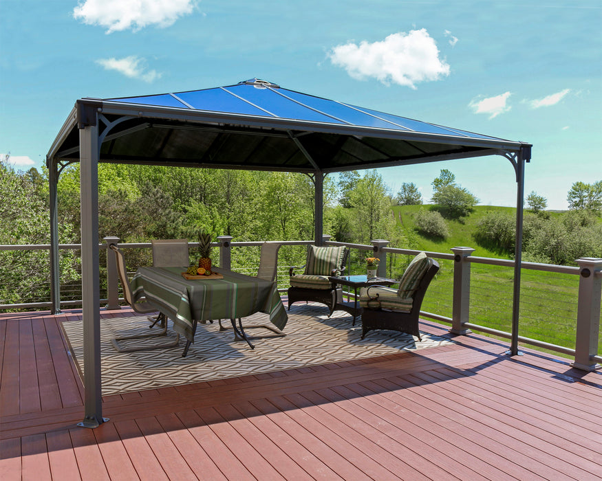 Modern backyard setup with Palermo 14x14 garden gazebo featuring grey aluminum structure and durable roof covering large outdoor dining area on concrete patio.
