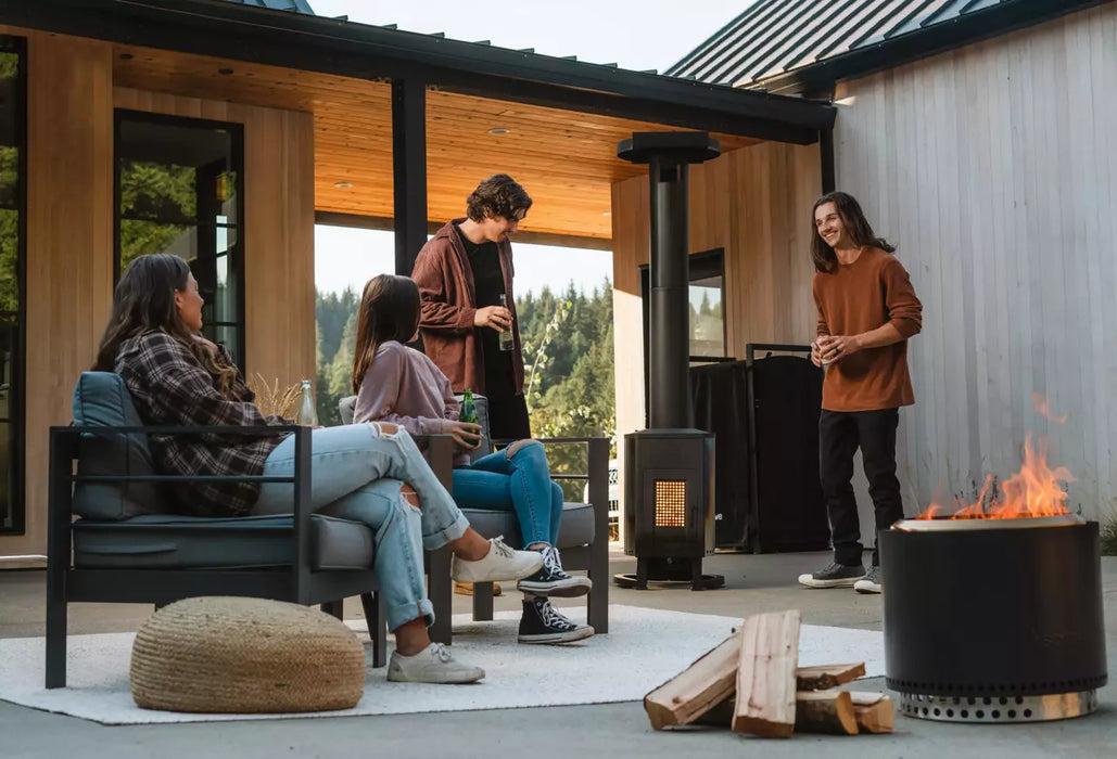  Friends socializing on a patio with the Solo Stove Tower Patio Heater in the background, enhancing the outdoor experience.