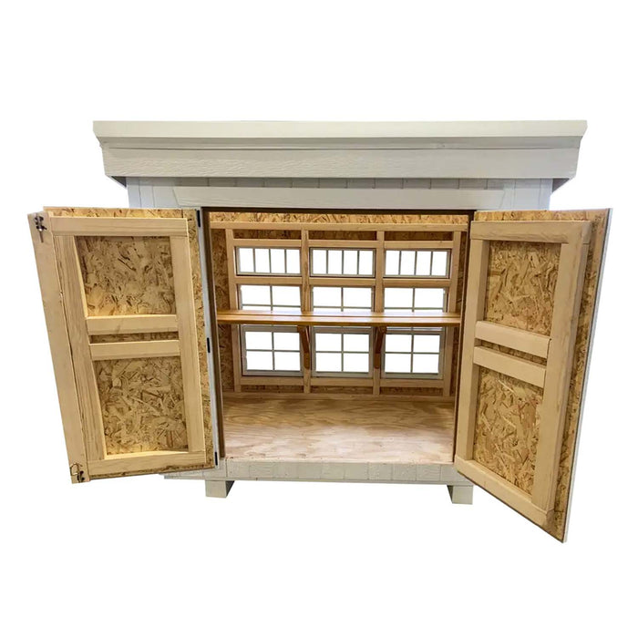 Little Cottage Co. Petite Greenhouse shown with double doors open, wood interior and windows designed for airflow and light for indoor gardening