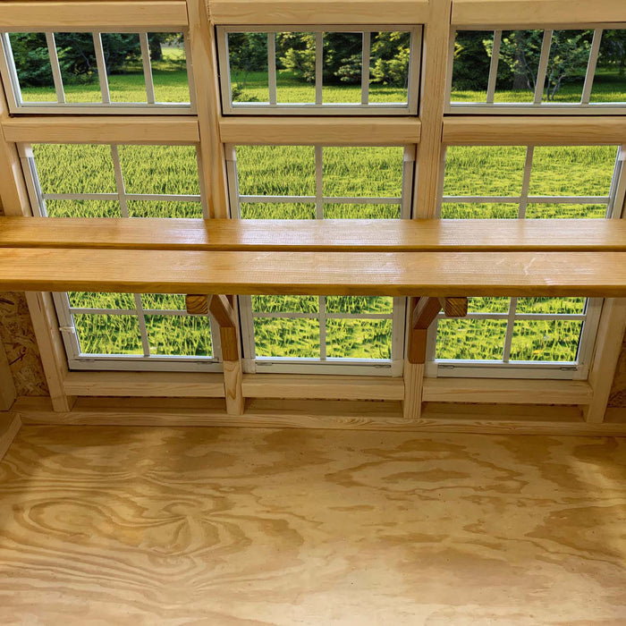 Interior of Petite Greenhouse by Little Cottage Co. featuring wood shelf and large multi-pane windows letting in natural light for growing plants