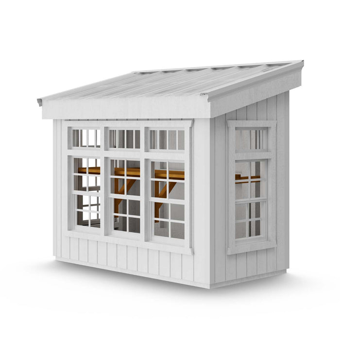 Side and back view of Petite Greenhouse by Little Cottage Co., featuring large windows, slanted roof, and primed white exterior for painting