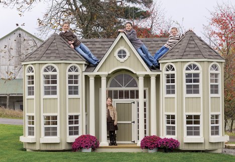 Kids enjoying the spacious Grand Mansion playhouse featuring a portico by Little Cottage Company.