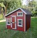 Ez-Fit Kits Playhouse Kit interior showing wood loft with railing, built-in ladder, framed walls, cozy armchair, area rug, and potted plant