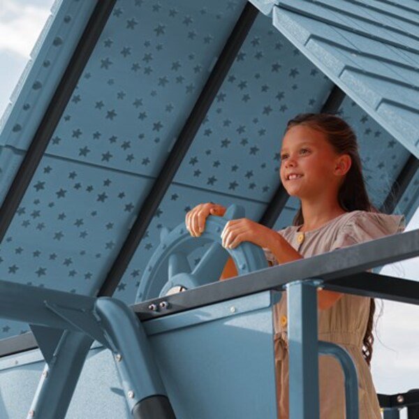 Close-up of a girl steering the ship wheel inside the Lifetime playset's clubhouse.
