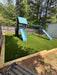 Lifetime Big Stuff Deluxe playset installed on artificial turf in a customer's backyard, wide angle view.