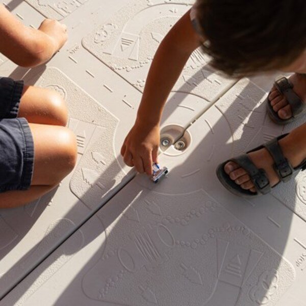 Close-up of kids playing with toy cars on the Lifetime playset tower floor's integrated car map design.
