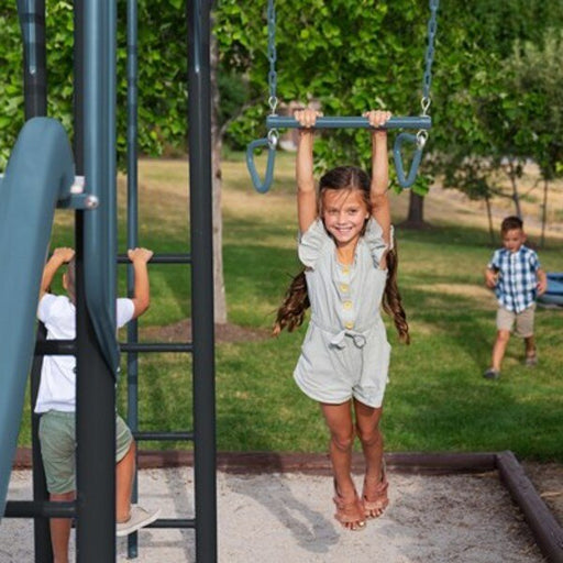 Girl hanging from the Lifetime playset's trapeze bar with gym rings while a boy climbs the ladder in the background.