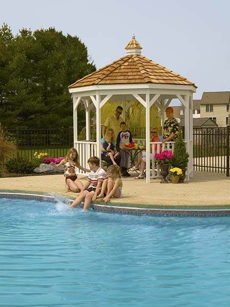 Vinyl Gazebo-In-A-Box with Floor beside a pool with a family