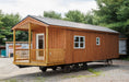 Detailed view of the porch area of the Oasis Tiny Estates Firestack Cabin, highlighting the sturdy wooden construction and cozy outdoor space.