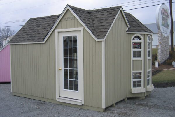 A side view of Little Cottage Company's Grand Portico Mansion playhouse displaying the side door and tall windows.