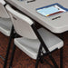 Lifetime 4-Pack Classic Folding Chair in putty tucked under folding table showing compact storage design
