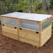 Three-quarter view of the 6x3 cedar Greenhouse with Garden in a Box, clear panel sides and hinged lids closed over the raised planting bed
