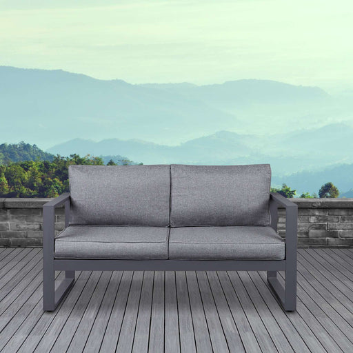Real Flame Baltic outdoor loveseat on a patio with mountain view, ideal for modern outdoor living.