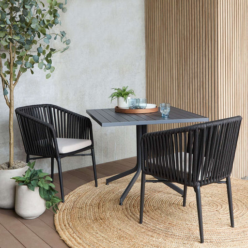 Real Flame Bodhi Outdoor Chair Set With Cushions in lifestyle setting with two black chairs and a small table