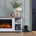 Close-up lifestyle view of Real Flame Tramore white electric fireplace TV stand in an entryway with copper watering can, flower vases, storage basket, and rain boots nearby