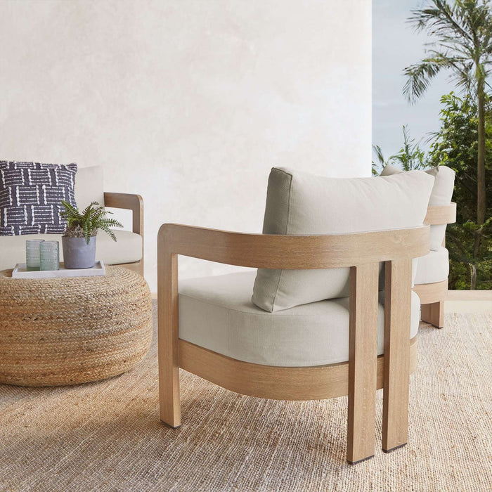 A close-up rear view of the chair’s curved wood frame and neutral cushions from the Real Flame Arlo Outdoor Seat Sofa with Cushions set.