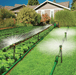 Riverstone Greenhouse Irrigation Systems installed in backyard garden with sprinkler heads watering vegetable rows