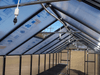 Riverstone Greenhouse Internal Watering System mounted along roof beams with multiple misting nozzles inside greenhouse.