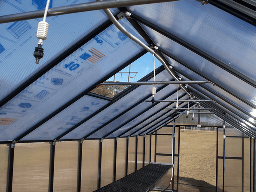Riverstone Greenhouse Internal Watering System mounted along roof beams with multiple misting nozzles inside greenhouse.