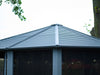 Exterior shot of the 12x12 Gazebo slate-colored metal roof, highlighting the peak and ridged design against a backdrop of trees.