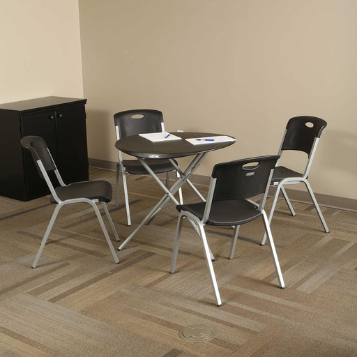 Small round table with four chairs from the Lifetime 4 Pack Stacking Chair collection in office setting.