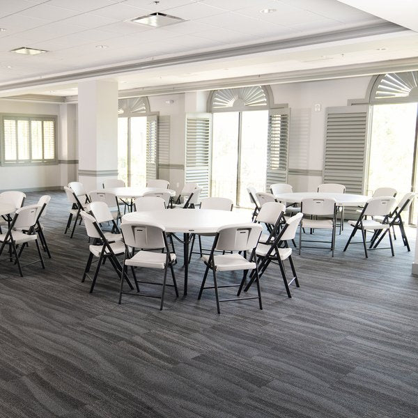 Wide view of Lifetime round folding tables and chairs arranged in a bright event room.