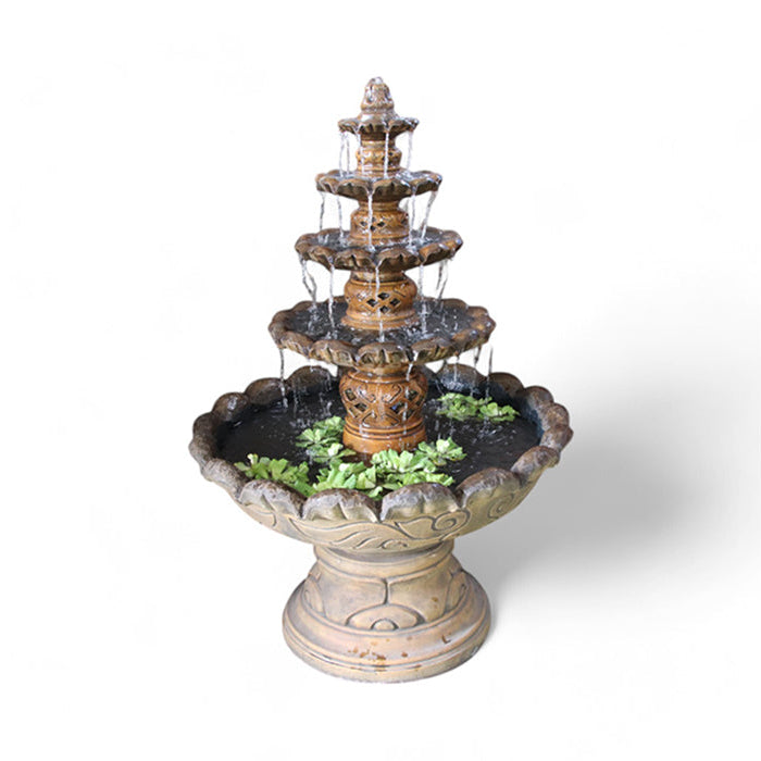 Rust colored Exaco Monaco Fountain with cascading water over four decorative tiers, surrounded by greenery, perfect for gardens and patios